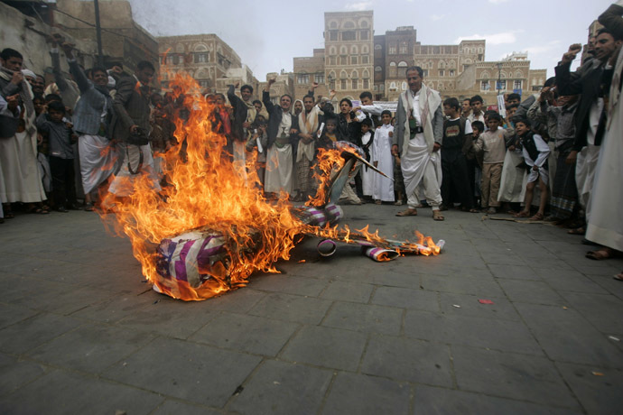 Protesters loyal to the Shi'ite al-Houthi rebel group burn an effigy of a U.S. aircraft during a demonstration to protest against what they say is U.S. interference in Yemen, including drone strikes, after their weekly Friday prayers in the Old Sanaa city April 12, 2013. (Reuters/Khaled Abdullah)