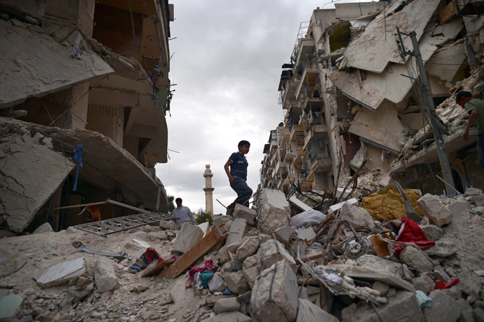 A Syrian boy walks on the rubble of destroyed buildings in the northern Syrian city of Aleppo (AFP Photo)