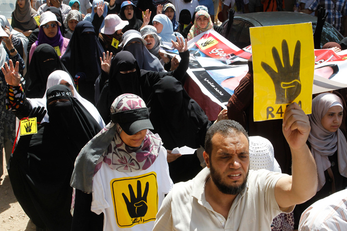 Supporters of Muslim Brotherhood and ousted Egyptian President Mohamed Morsi hold up posters of the "Rabaa" gesture, in reference to the police clearing of Rabaa Adawiya protest camp on August 14, during a protest in Cairo August 23, 2013 (Reuters / Muhammad Hamed)