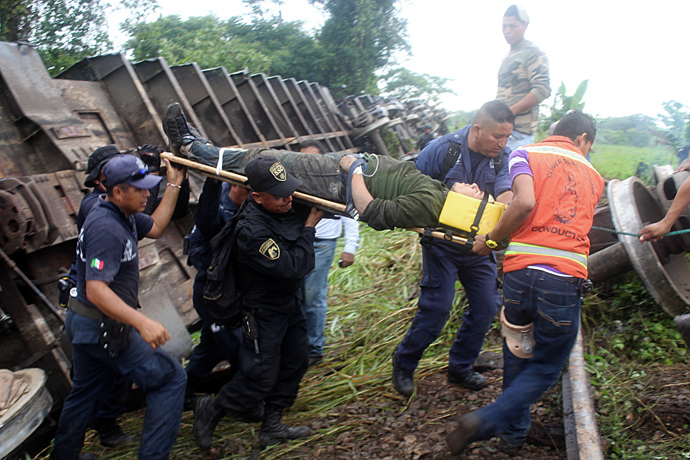 Alleged immigrant being pulled from under the train known as "The Beast" which derailed near Huimanguillo, in Tabasco State, Mexico, on August 25, 2013 (AFP Photo / Tabasco Hoy)