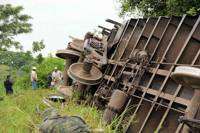 Federal policemen, soldiers and rescuers working at the site where the train known as "The Beast" derailed, near Huimanguillo, in Tabasco State, Mexico, on August 25, 2013 (AFP Photo / Civil Protection Mexico) 
