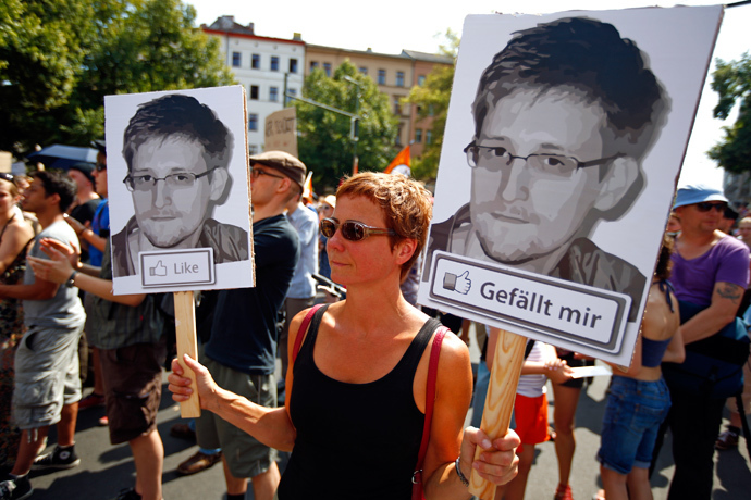 A protester carry two portraits of Edward Snowden during a demonstration against secret monitoring programmes PRISM, TEMPORA, INDECT and showing solidarity with whistleblowers Edward Snowden, Bradley Manning and others in Berlin July 27, 2013 (Reuters / Pawel Kopczynski)