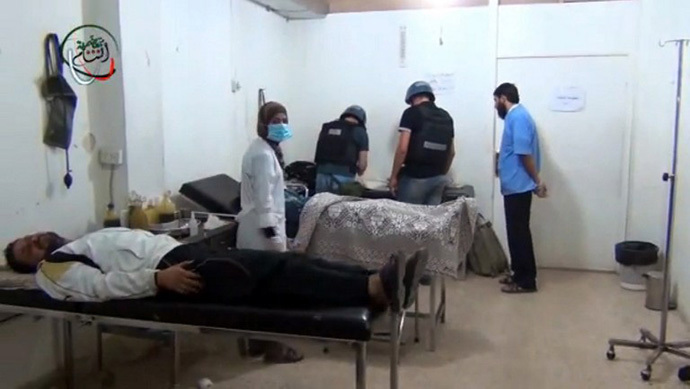 An image grab taken from a video uploaded on YouTube allegedly shows a UN inspectors (C) visiting a hospital in the Damascus suburb of Moadamiyet al-Sham. (AFP Photo)