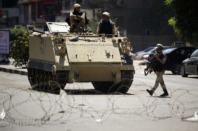  Egyptian army soldiers sit on top of an armoured personnel carrier behind a barbed wire checkpoint as they guard a street that leads to Cairo's Mustafa Mahmoud mosque, in a bid to prevent supporters of toppled Islamist president Mohamed Morsi from demonstrating in the square on August 23, 2013. (AFP Photo)