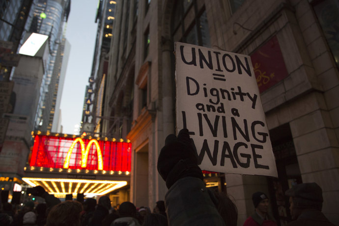 A protester holds up a sign at a demonstration outside McDonald's in Times Square in support of employees on strike at various fast-food chains in New York November 29, 2012. (Reuters/Andrew Kelly)