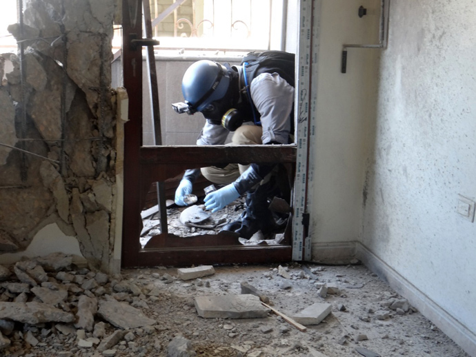 A United Nations (UN) arms expert collects samples as they inspect the site where rockets had fallen in Damascus' eastern Ghouta suburb during an investigation into a suspected chemical weapons strike near the capital (AFP Photo / Ammar Al-Arbini)