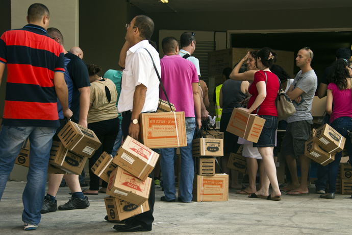 Israelis queue up to collect gas mask kits at a distribution center in the Mediterranean coastal city of Haifa, northern Israel, on August 29, 2013 (AFP Photo)