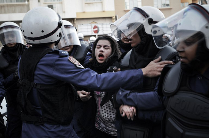 A protestor cries after being pepper sprayed as she is arrested by riot policemen during a demonstration called for by the February 14 Youth Coalition, an Internet group that regularly calls for protests in the Shiite-majority kingdom on January 18, 2013 in the capital Manama. (AFP Photo / Mohammed Al-Shaikh)