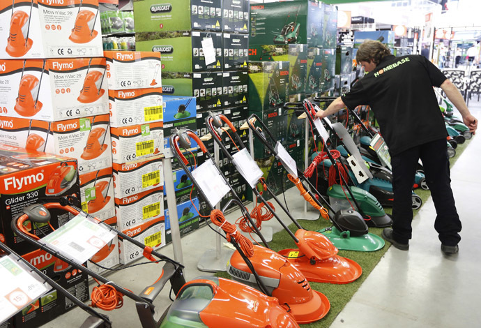 A sales assistant works on a display of lawnmowers at a Homebase store in Aylesford, South East England. (Reuters/Luke MacGregor)