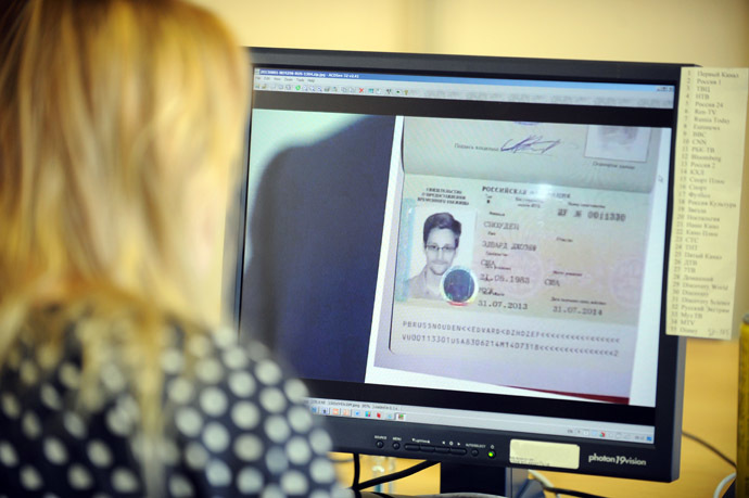 A woman watches a footage on her computer, showing the lawyer of fugitive US intelligence leaker Edward Snowden showing his client's one year's asylum permit at Sheremetyevo airport in Moscow on August 1, 2013. (AFP Photo)