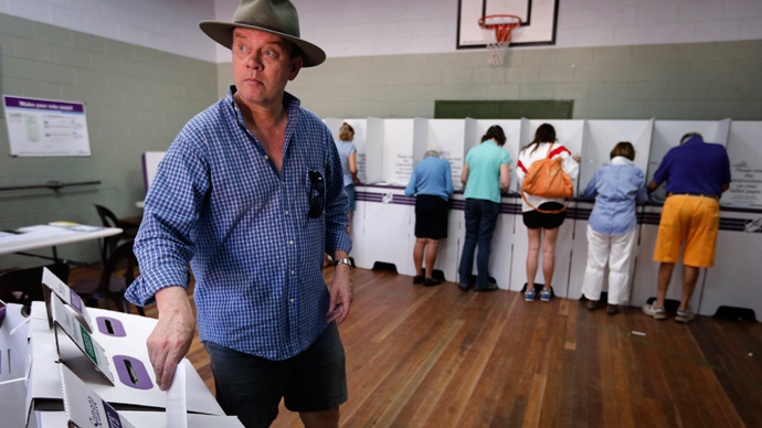 A man wearing an Australian bush hat casts his vote at a polling booth located in a small hall in Sydney September 7, 2013 (Reuters / David Gray)