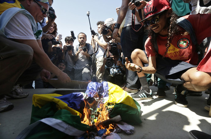 Demonstrators burn a Brazilian flag during a protest on Brazil's Independence Day in Rio de Janeiro September 7, 2013. (Reuters/Ricardo Moraes)