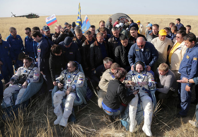 US astronaut Chris Cassidy (L) together with Russian cosmonauts Pavel Vinogradov (C) and Alexander Misurkin (R) rest shortly after their landing on board the Soyuz TMA-08M space capsule some 146 km southeast of the town of Zhezkazgan in Kazakhstan,, on September 11, 2013. (AFP Photo/Maxim Shipenlov)
