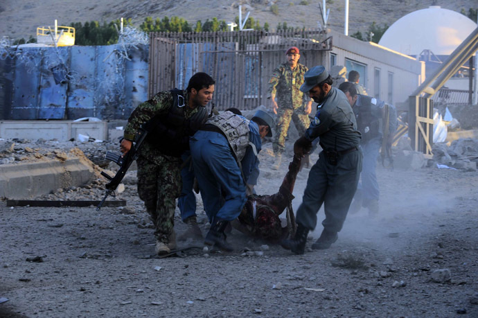 Afghanistan security forces lift a dead body of their colleague during an attack on the US consulate in Herat on September 13, 2013. (AFP Photo/Aref Karimi)