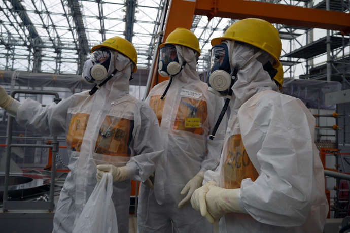 This handout picture taken by Tokyo Electric Power Co (TEPCO) on September 12, 2013 shows Luke Barret (C), external professional for TEPCO's contaminated water and tank countermeasures headquarters, inspecting TEPCO's Fukushima Dai-ichi nuclear power plant at Okuma town in Fukushima prefecture. (AFP/TEPCO)