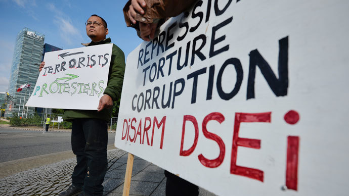 A protester carries a poster during a demonstration against the Defence and Security Equipment International (DSEI) arms fair at the ExCeL centre in east London, on September 10, 2013.(AFP Photo / Ben Stansall)