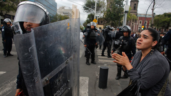 A woman pleads for no more violence to a riot federal police officer after striking members of the teachers' union CNTE were evicted from Zocalo Square in downtown Mexico City September 13, 2013.(Reuters / Tomas Bravo)