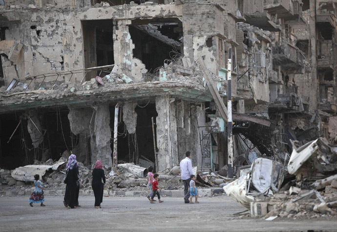 People walk along a damaged street filled with debris in Deir al-Zor September 4, 2013. (Reuters//Khalil Ashawi)