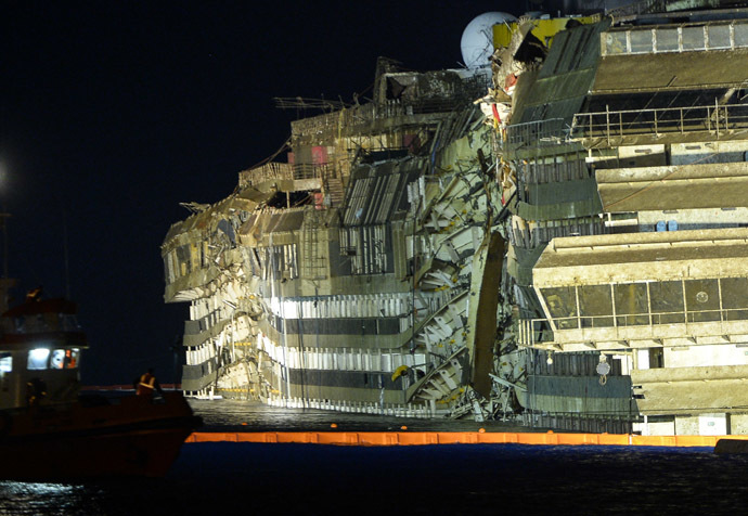 The wreck of Italy's Costa Concordia cruise ship begins to emerge from water on September 17, 2013 near the harbour of Giglio Porto. (AFP Photo/Andreas Solaro)