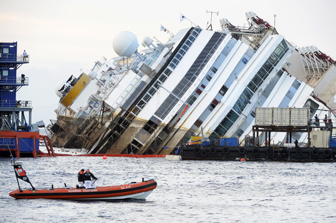 Coast guards patrol near the wreck of Italy's Costa Concordia cruise ship which begins to emerge from water on September 16, 2013 near the harbour of Giglio Porto. (AFP Photo/Andreas Solaro)