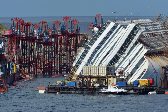 Members of the US salvage company Titan and Italian firm Micoperi work at the wreck of Italy's Costa Concordia cruise ship near the harbour of Giglio Porto on September 16, 2013. (AFP Photo/Vincenzo Pinto)