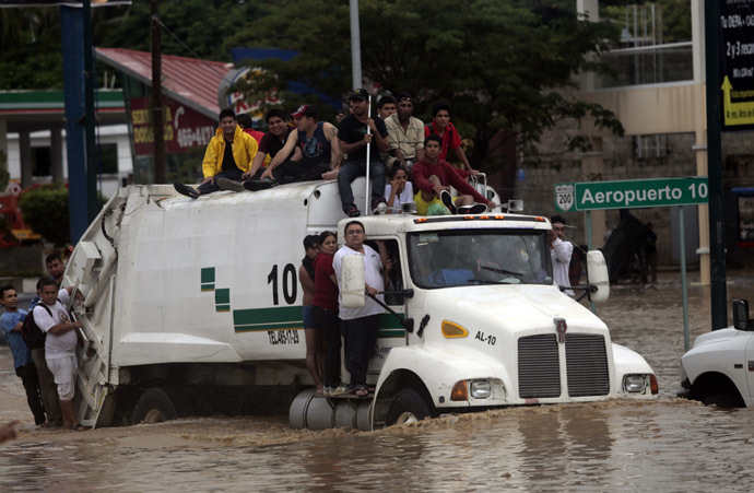 Residents attempt to leave the flooded area in Acapulco, Guerrero state, Mexico, after heavy rains hit the area on September 16, 2013. (AFP Photo/Pedro Pardo)