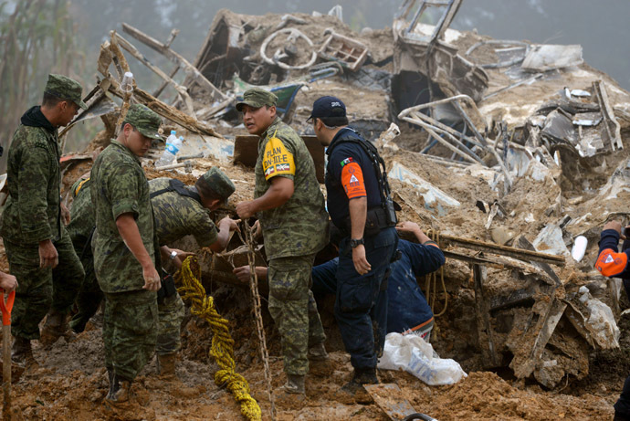 Mexican soldiers and police look for victims of a landslide caused by heavy rains in Xaltepec community, State of Veracruz, Mexico on September 16, 2013. (AFP Photo)