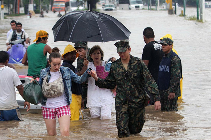 Tourists wade through a flooded street in Acapulco, Guerrero state, Mexico, after heavy rains hit the area on September 16, 2013 (AFP Photo)