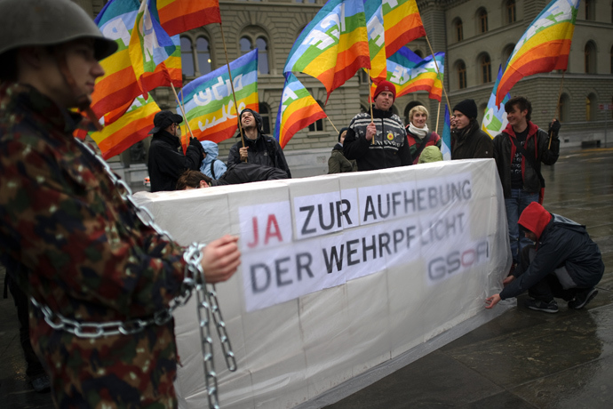 Members of the Group for Switzerland without an Army (GSoA) demonstrate next to boxes with some 107'280 signatures collected for a popular initiative to end military conscription, outside of the Swiss House of Parliament (AFP Photo / Fabrice Coffrini)