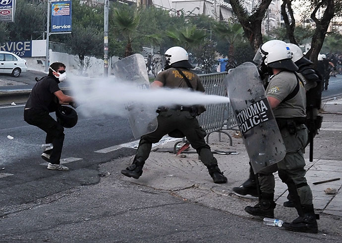 Police spray a protester with tear gas during clashes with anti-fascist demonstrators in the western Athens working class suburb of Keratsini on September 18, 2013, after a leftist musician was murdered by a suspected neo-Nazi. (AFP Photo / Louisa Gouliamaki)