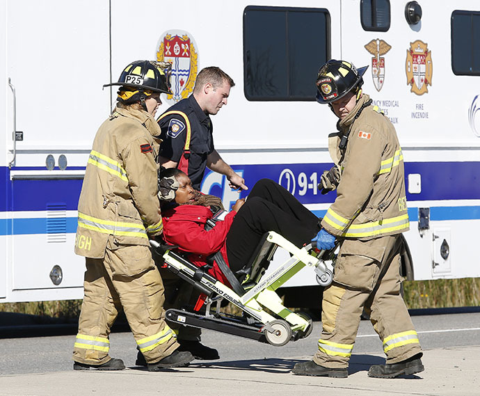 Emergency workers take a person away at the scene of an accident involving a bus and a train in Ottawa September 18, 2013. (Reuters / Chris Wattie)