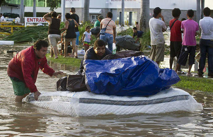 Looters flee with goods from a supermarket in Acapulco, state of Guerrero, Mexico, on September 17, 2013 as heavy rains hit the country. (AFP Photo / Ronaldo Schemidt)