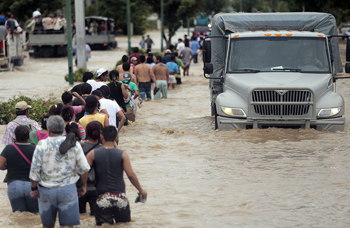Residents and tourists wade through a flooded street in Acapulco, Guerrero state, Mexico, on September 17, 2013 as heavy rains hit the country. (AFP Photo / Pedro Pardo)