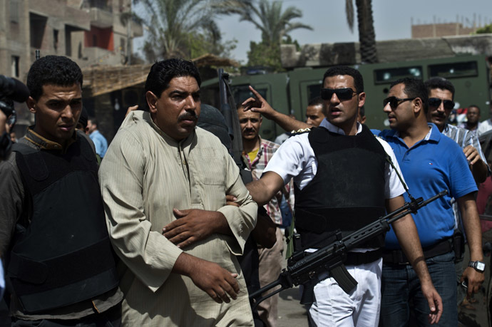 Egyptian armed policemen arrest a man during a raid in the village of Kerdasa on the outskirts of Cairo, on September 19, 2013. (AFP Photo)