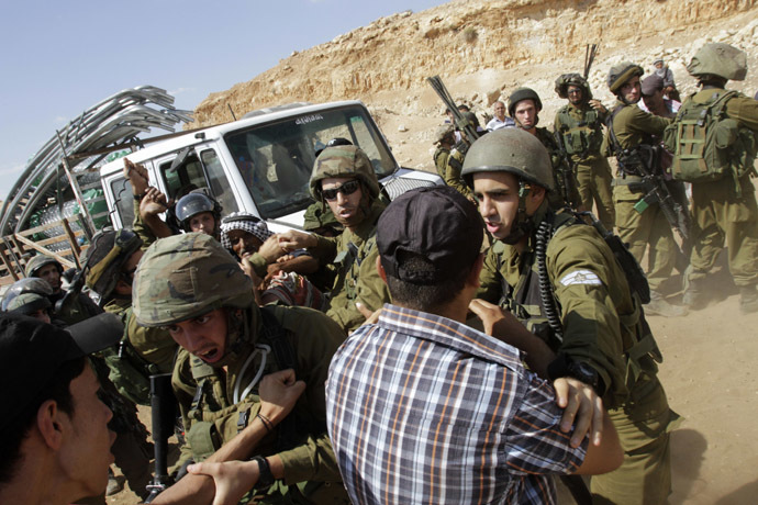 Israeli soldiers scuffle with Palestinians near a truck loaded with items European diplomats wanted to deliver to locals in the West Bank herding community of Khirbet al-Makhul, in the Jordan Valley September 20, 2013. (Reuters/Abed Omar Qusini)