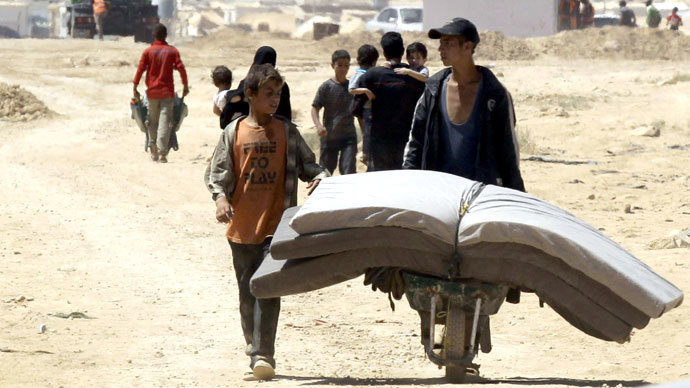 Young Syrian refugeestransport mattresses through the Zaatari refugee camp, located close to the Jordanian city of Mafraq, near the border with Syria.(AFP Photo / Khalil Mazraawi)