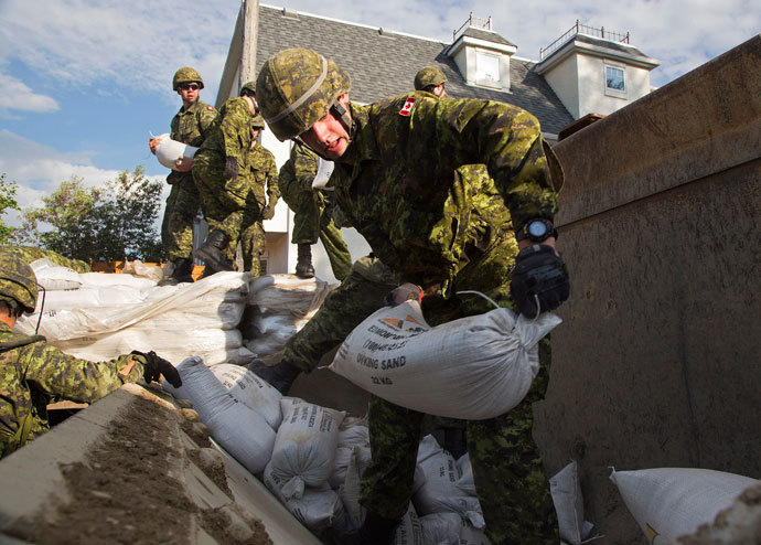 Canadian Armed Forces soldiers from the The Calgary Highlanders start to sandbag from the rising Bow River in the community of Ingelwood in Calgary, Alberta June 22, 2013.(Reuters / Melissa Renwick)