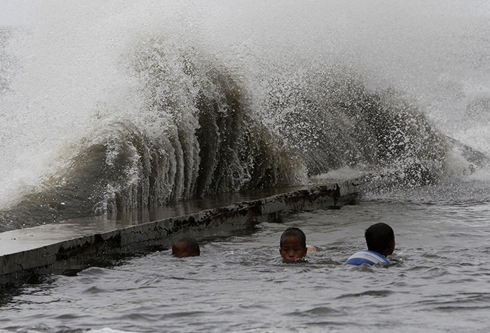 Children swim in a flooded walkway as rough waves crash on concrete banks along the coast of Manila Bay brought by Super Typhoon Usagi in Navotas City, metro Manila September 21, 2013. (Reuters / Romeo Ranoco)