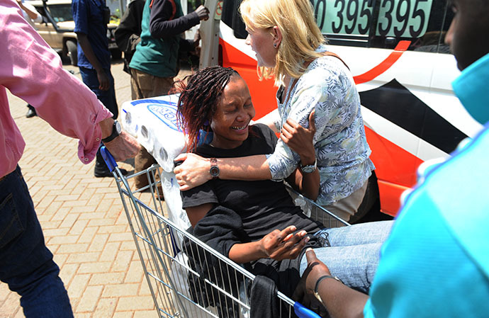 A woman is trolled into an ambulance after masked gunmen stormed an upmarket mall and sprayed gunfire on shoppers and staff, killing at least fifty nine on September 21, 2013 in Nairobi. (AFP Photo / Simon Maina)