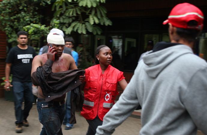 An injured Kenyan man talks on the phone upon his arrival at the Aga Khan Hospital in Nairobi, on September 21,2013 after masked attackers stormed a packed upmarket shopping mall, spraying gunfire and killing 59 people and wounding dozens more before holing themselves up in the complex (AFP Photo / Hoss Njuguna)