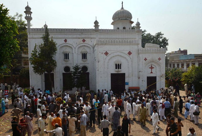 Pakistani Christians and security officials gather outside the Church after two suicide bomb attacks in Peshawar on September 22, 2013. (AFP Photo / A. Majeed)