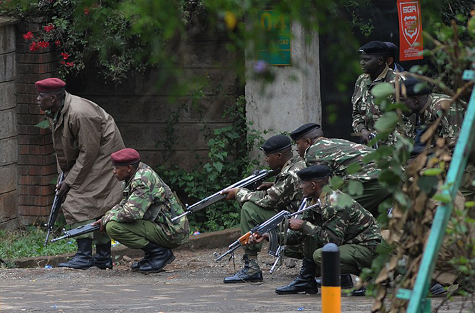 Armed Kenyan policemen take cover outside theWestgate mall in Nairobi, on September 23, 2013. (AFP Photo / Simon Maina)