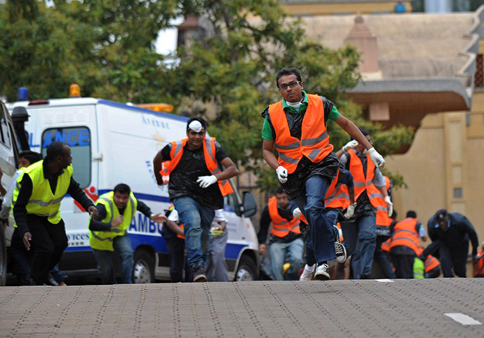 Volunteers from the asian-community run for cover on September 23, 2013, after hearing a volley of gunshots at the scene of a siegeof an upmarket shopping mall by al-shebab, Somalia based al-Qaeda linked terror network. (AFP Photo / Tony Karumba)