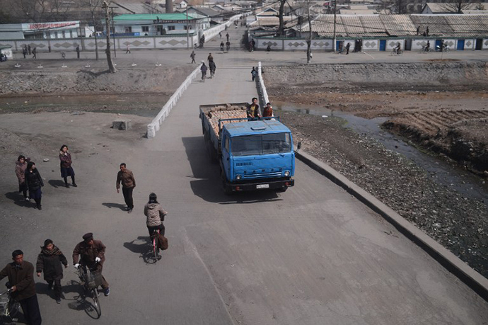 North Koreans are seen from the window of a train along the railway line between Pyongyang and the North Phyongan Province on the west coast (AFP Photo / Pedro Ugarte)