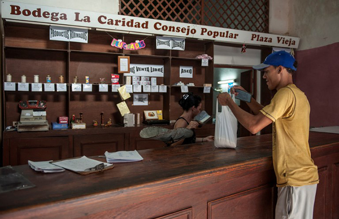 A customer gets his monthly rice quota in a store where people can use their "libreta", a ration card which since 1963 has allowed Cubans to buy basic food supplies at cheap -- and heavily subsidized -- prices, in Havana (AFP Photo)