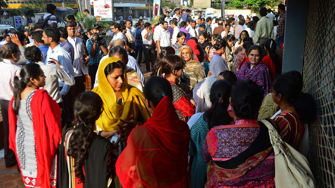 Pakistani pedestrians and office workers leave an office building after an earthquake in Karachi on September 24, 2013. (AFP Photo/Rizwan Tabassum)