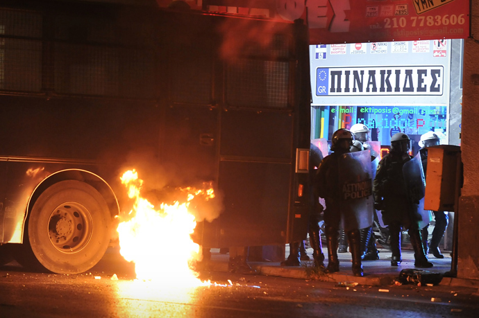 A molotov cocktail burns next to a riot police van on September 25, 2013 at the end of massive demonstration against the fatal September 18 stabbing of 34-year-old musician Pavlos Fyssas by unemployed truck driver George Roupakias (AFP Photo)