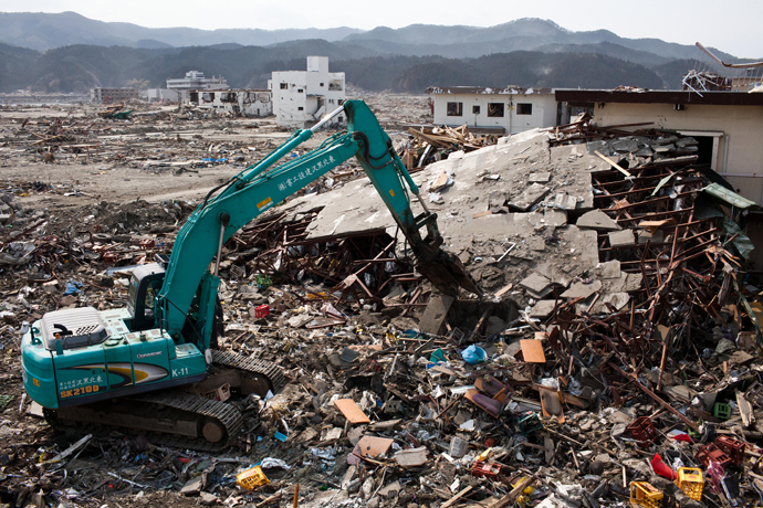 Japanese workers use a hydraulic machine to demolish a wrecked building in the tsunami-devastated town of Rikuzentakata, Iwate prefecture, on April 2, 2011 (AFP Photo / Yasuyoshi Chiba)