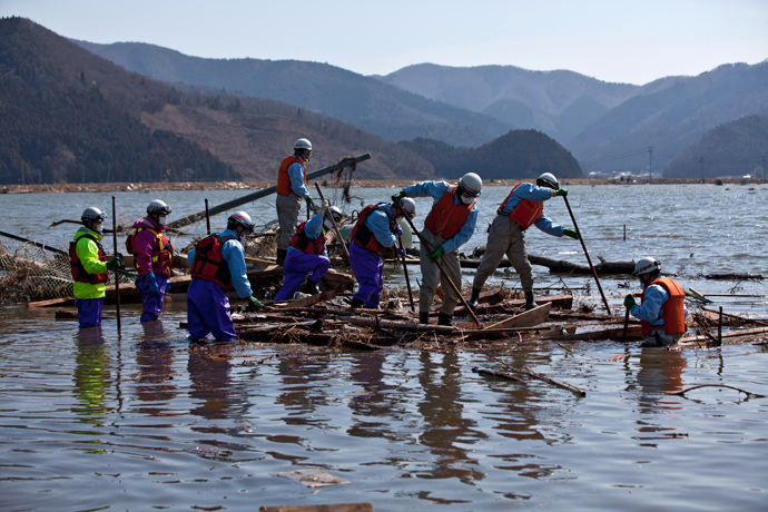 Japanese firemen pick through the rubble looking for bodies of victims of the tsunami in a flooded area of Ishinomaki in Miyagi prefecture on April 1, 2011 (AFP Photo / Yasuyoshi Chiba)