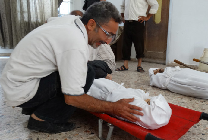 A handout image released by the Syrian opposition's Shaam News Network on August 23, 2013, shows a relative weaping over the boody of one of his family members killed during what Syrian rebels claim to be a toxic gas attack by pro-government forces in eastern Ghouta earlier in the week, during their funeral on the outskirts of Damascus. (AFP/Shaam News Network)